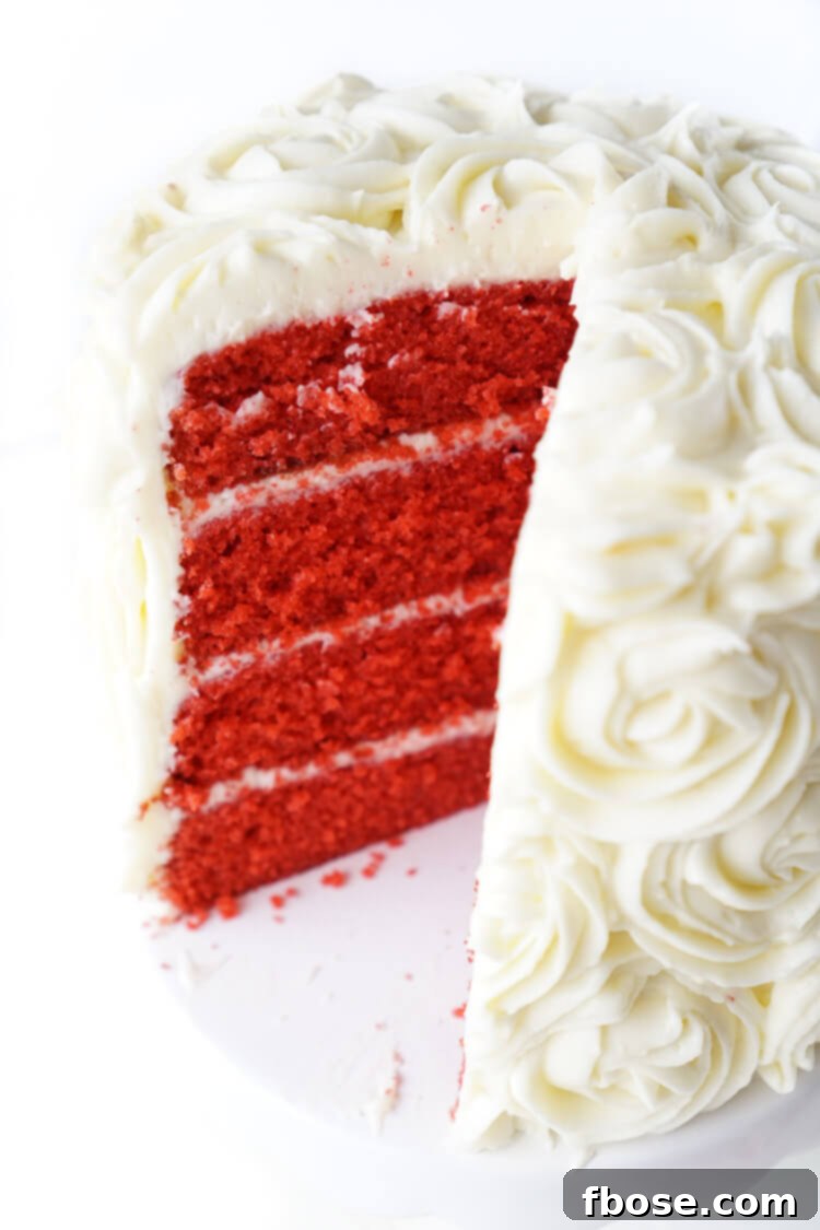 A beautifully decorated Red Velvet Cake, with delicate white frosting roses, served on a cake stand, embodying the elegance and subtle menace of President Snow.