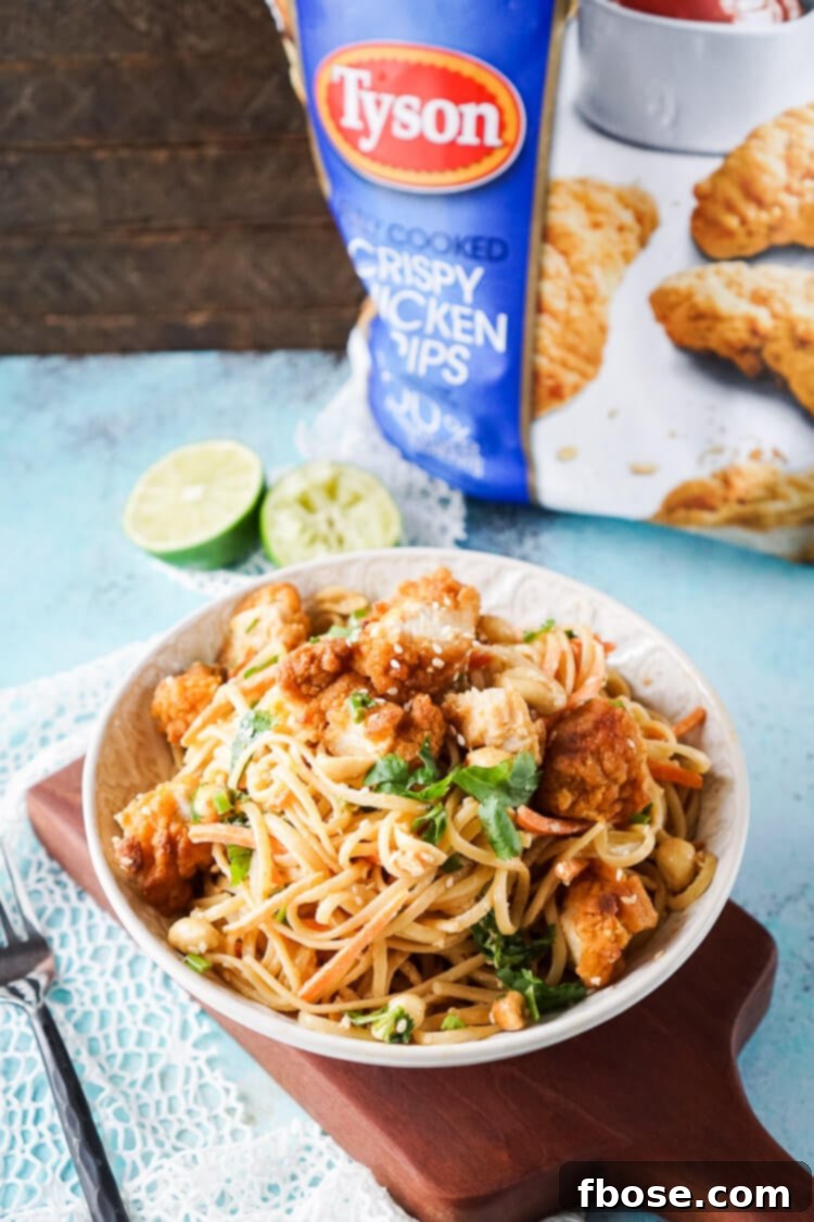 Crispy chicken and noodles coated in a savory Thai peanut sauce, ready for a cozy movie night at home.