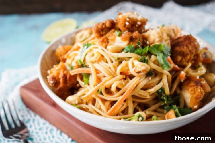 A close-up of crispy chicken pieces ready to be added to the flavorful Thai peanut noodles.