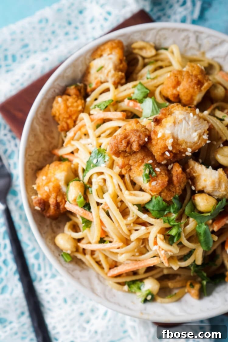 Close-up of Crispy Chicken Thai Peanut Noodles, showcasing the perfectly coated pasta and golden chicken.