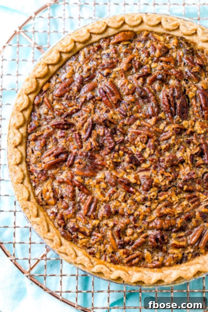 A close-up of a slice of pecan pie with a flaky crust.