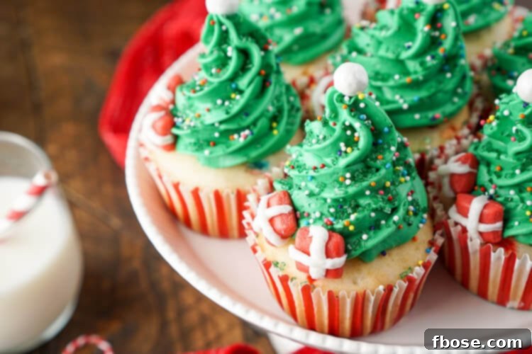 A close-up shot of a single Christmas Tree Cupcake, perfectly frosted and adorned with sprinkles and a Starburst present