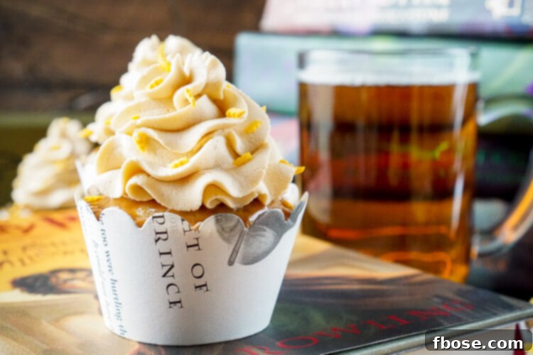 Close-up of a frosted Harry Potter Butterbeer Cupcake, showing the fluffy cake, creamy frosting, and sprinkle details.