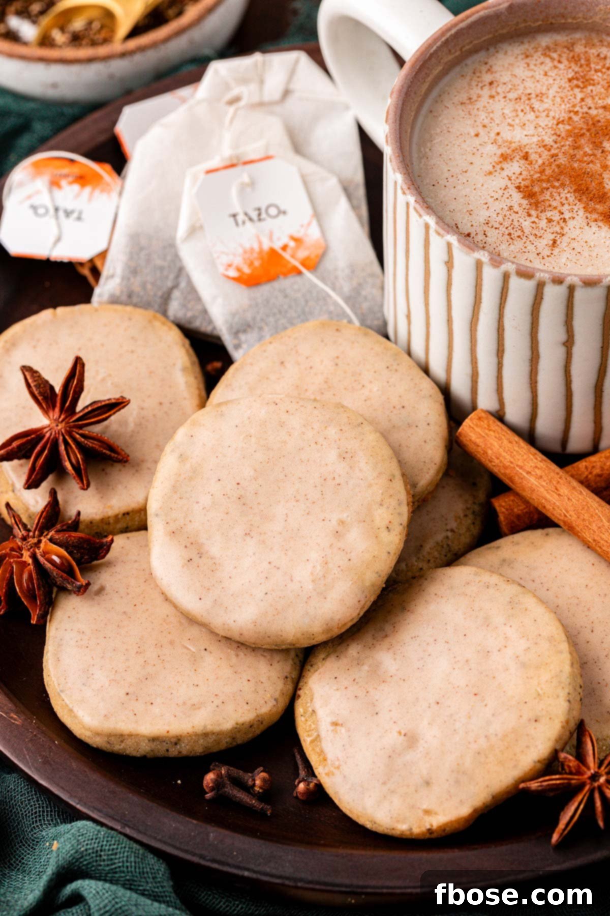 Close up of chai cookies on a plate with a mug of chai.