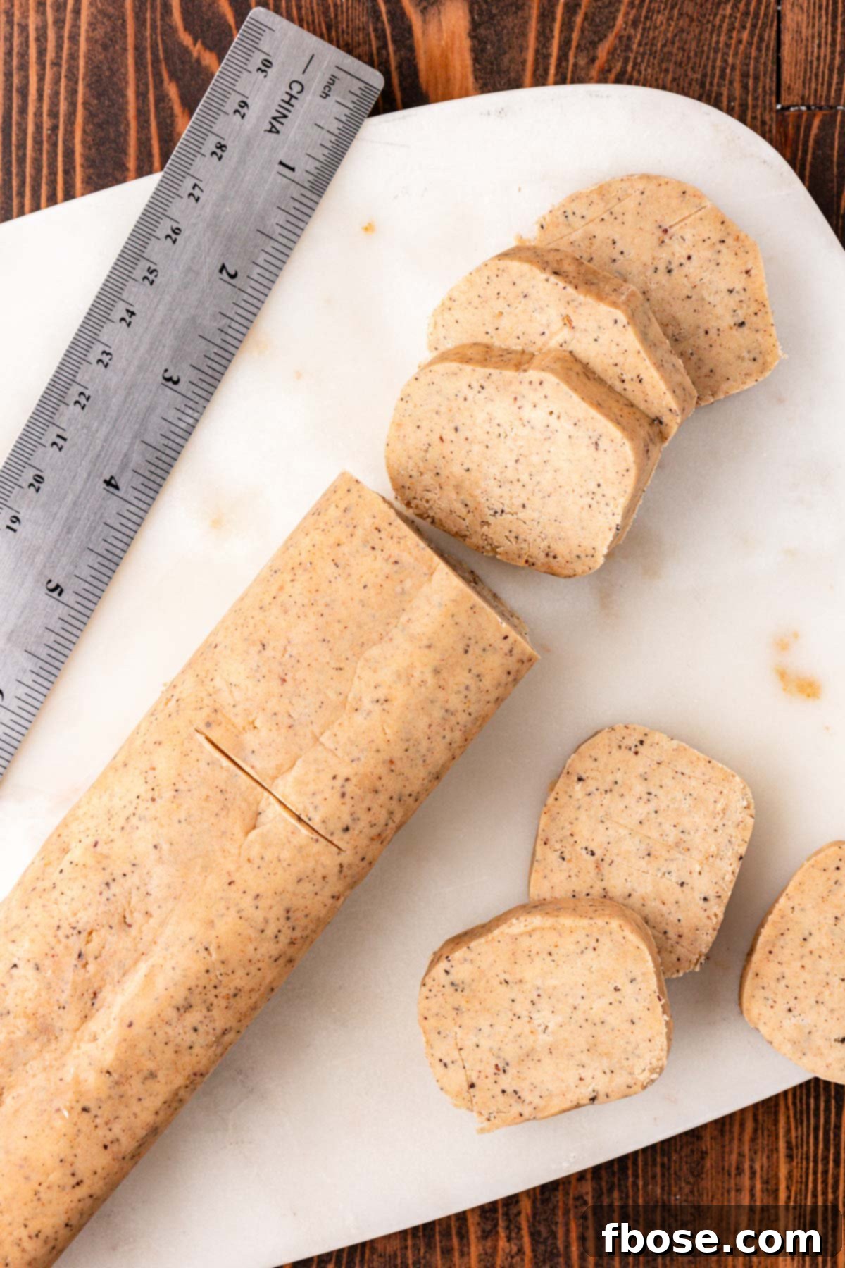 Shortbread slice and bake cookies being cut on a cutting board.