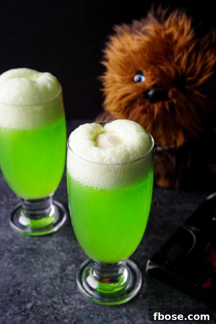 A Yoda Soda Float in a glass, with a small Yoda action figure beside it, setting a perfect scene for a Star Wars movie night.