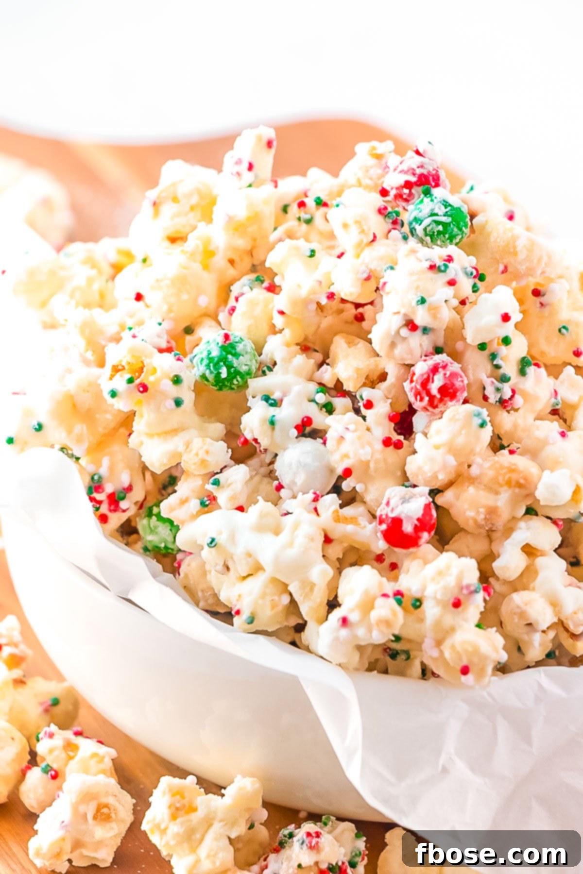 Close up photo of Christmas Popcorn in a small white bowl, showcasing the festive colors and textures.
