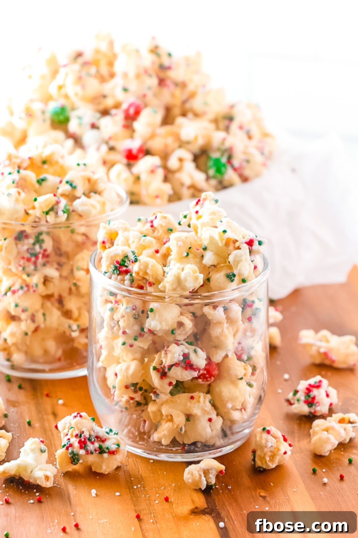 Christmas popcorn mixture being served in festive glasses, highlighting its appeal as a party snack.