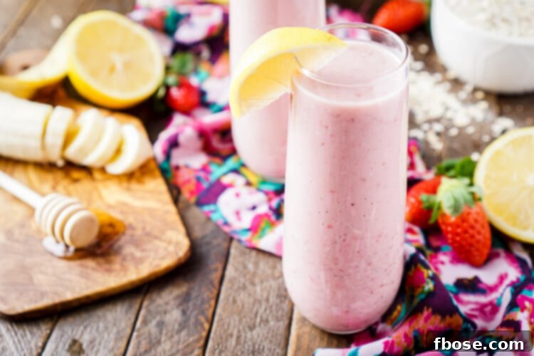 Zesty Berry Banana Bliss 5 A refreshing Strawberry Banana Lemon Smoothie served in a glass, garnished with fresh strawberries
