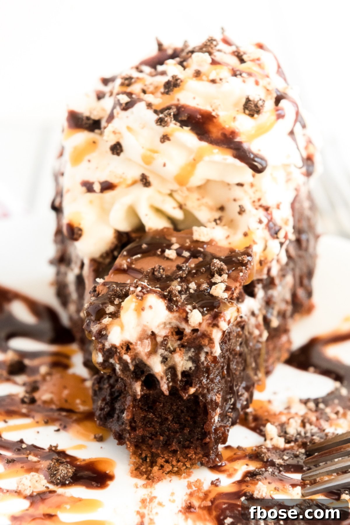 Fudgy Brownie Pie 2 Decadent Brownie Pie with caramel and chocolate drizzle, topped with whipped cream, ready to be served on a pristine white stand.