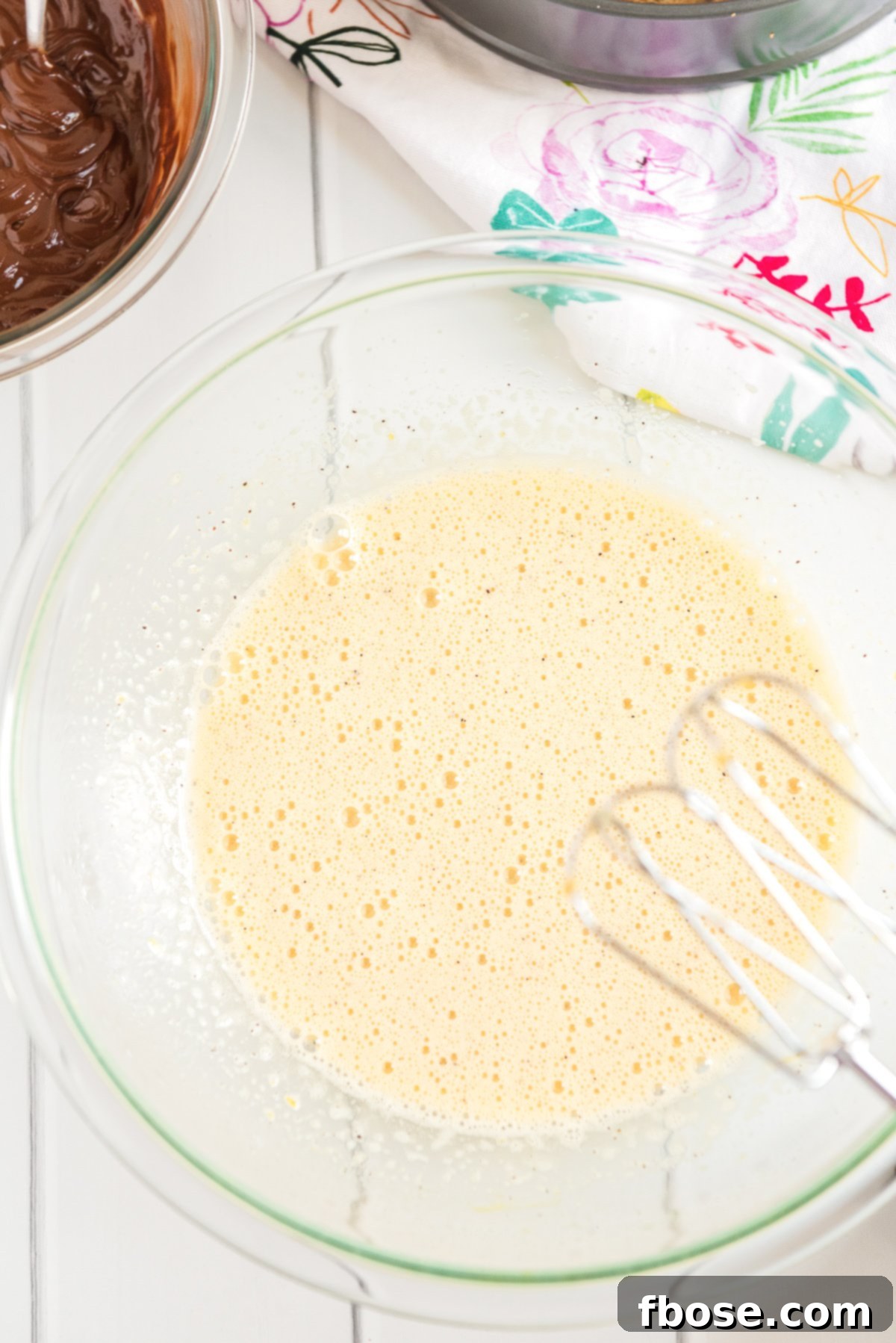 Fudgy Brownie Pie 6 Eggs, sugar, coffee granules, and vanilla extract vigorously beaten together in a glass mixing bowl, forming a light and airy mixture.