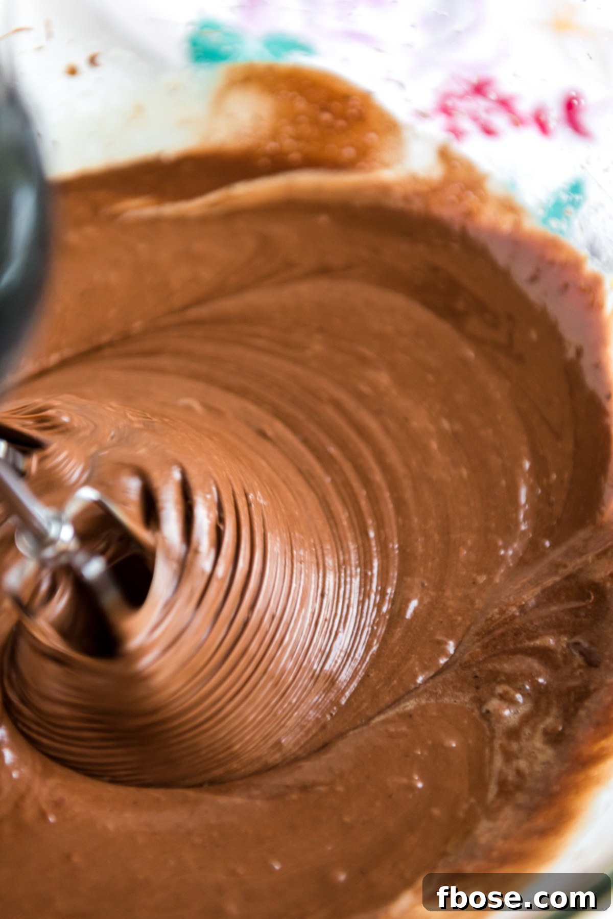 Fudgy Brownie Pie 7 Brownie batter being gently mixed with a hand mixer after adding dry ingredients, ensuring a smooth and perfectly combined consistency.