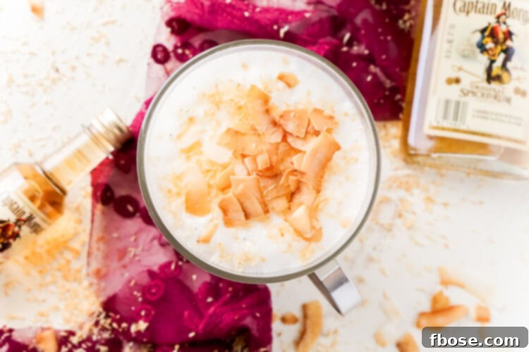 This Spiked Coconut Vanilla Steamer is one of the coziest winter cocktails you'll ever have! Made with real vanilla beans, coconut, milk, and spiced rum! It's delicious and frothy and topped with toasted coconut!