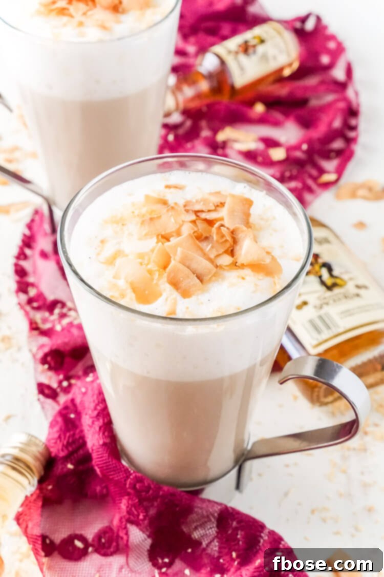 This Spiked Coconut Vanilla Steamer is one of the coziest winter cocktails you'll ever have! Made with real vanilla beans, coconut, milk, and spiced rum! It's delicious and frothy and topped with toasted coconut!