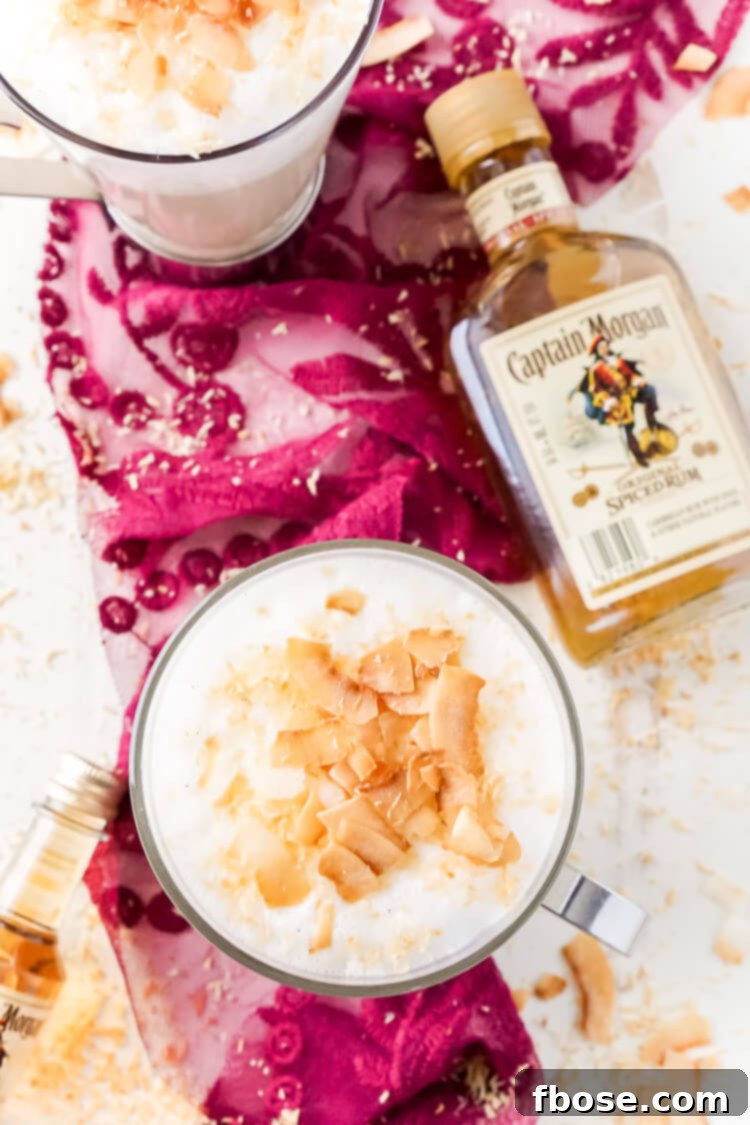This Spiked Coconut Vanilla Steamer is one of the coziest winter cocktails you'll ever have! Made with real vanilla beans, coconut, milk, and spiced rum! It's delicious and frothy and topped with toasted coconut!