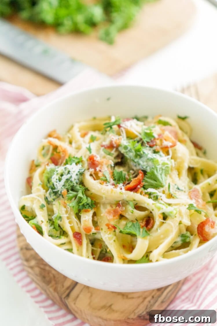 Overhead shot of a large serving of Bacon and Broccoli Fettuccine Alfredo, ready to be enjoyed.