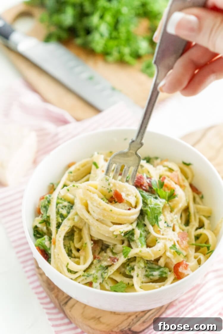Another enticing angle of Bacon and Broccoli Fettuccine Alfredo, highlighting the steam and freshness.