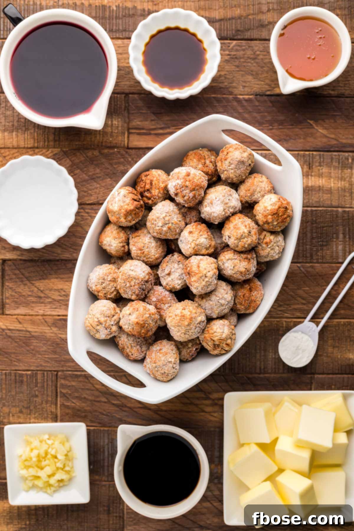 Ingredients to make Merlot Meatballs on a wooden surface.
