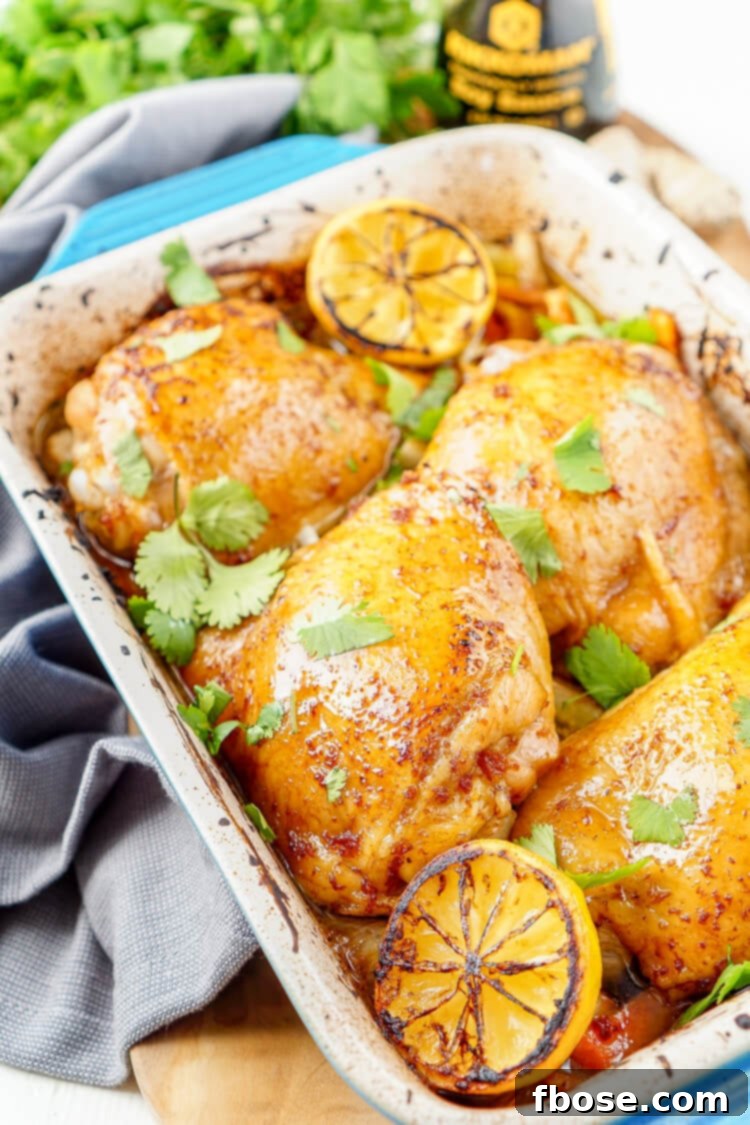A baking dish filled with golden-brown Lemon Ginger Soy Chicken Thighs and vibrant roasted vegetables like bok choy and carrots, fresh from the oven.