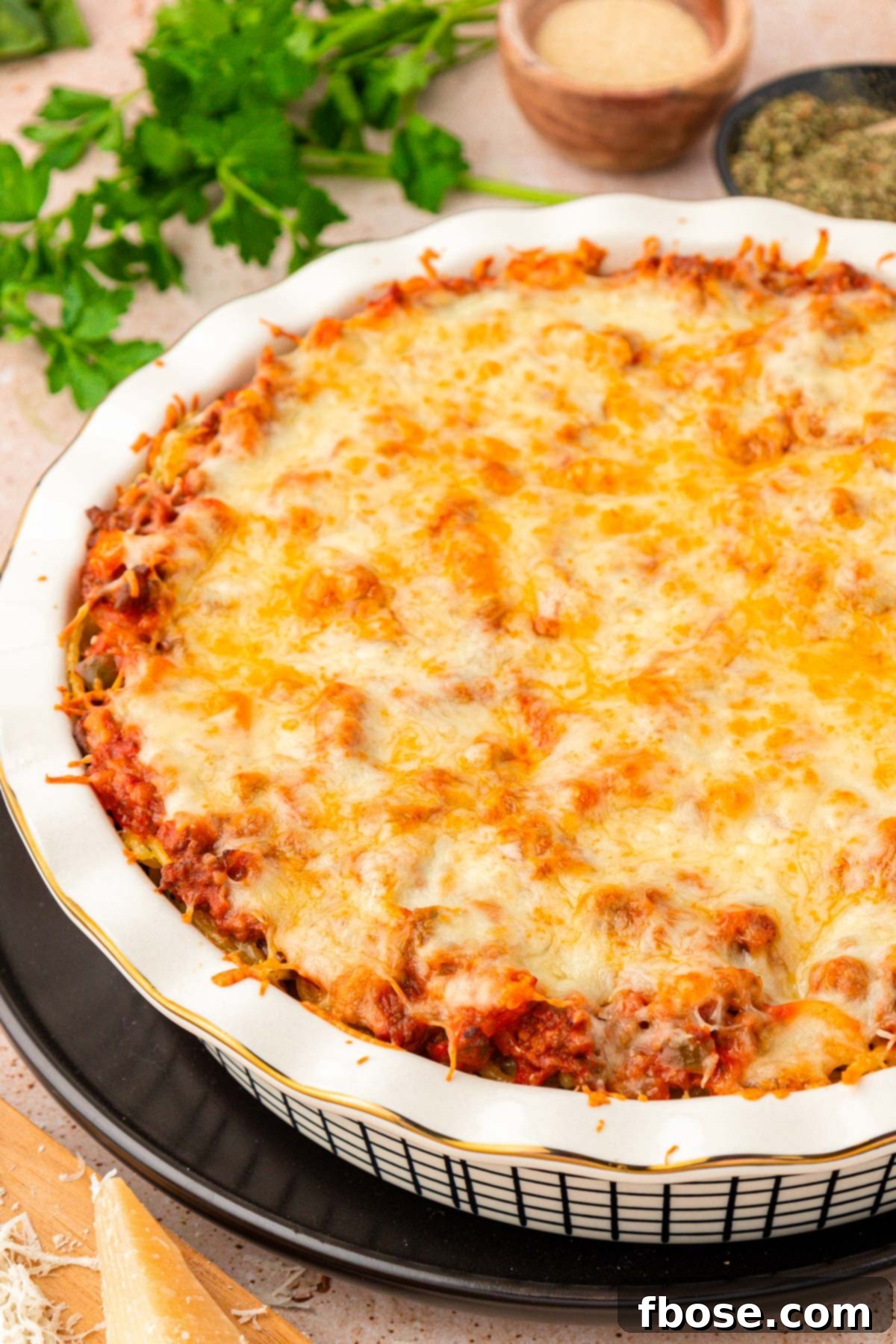 A close up photo of spaghetti pie in a white pie dish.