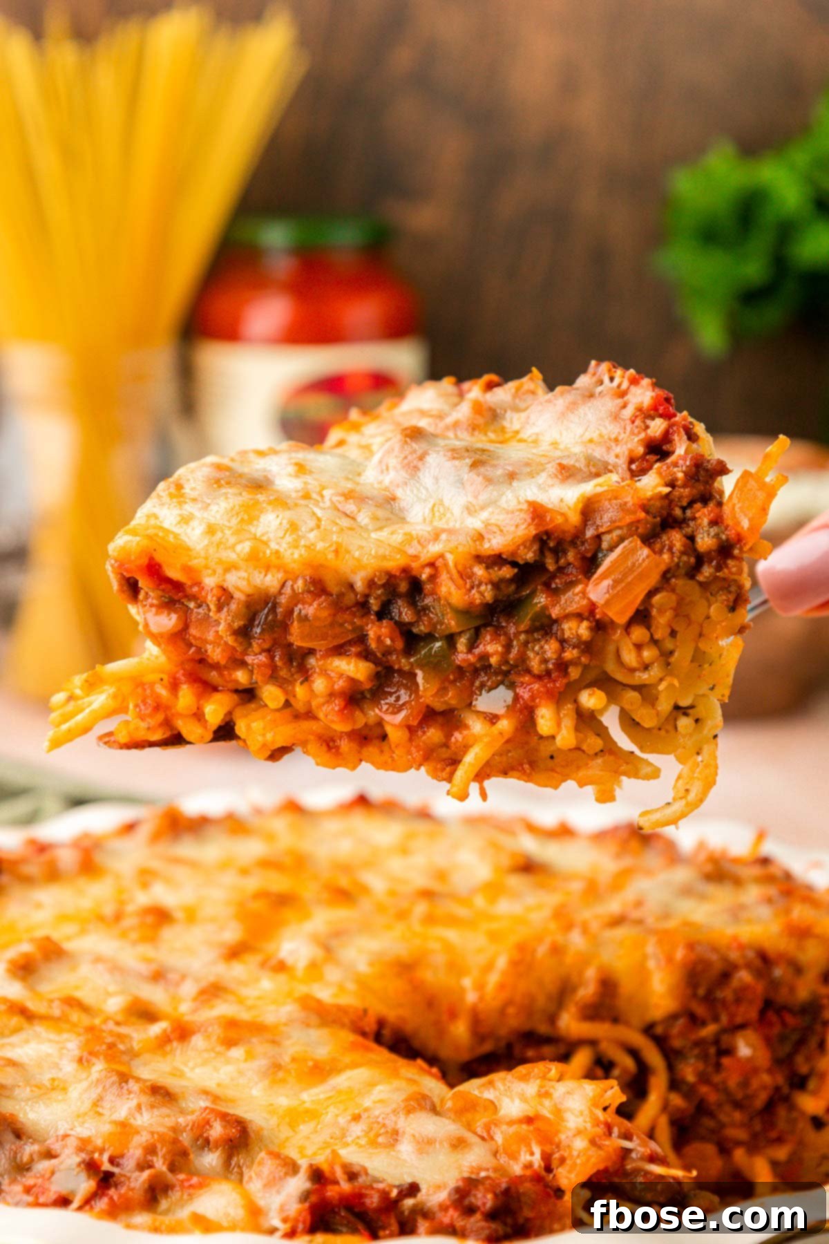 Spaghetti Pie on a spatula being lifted from a pie dish.