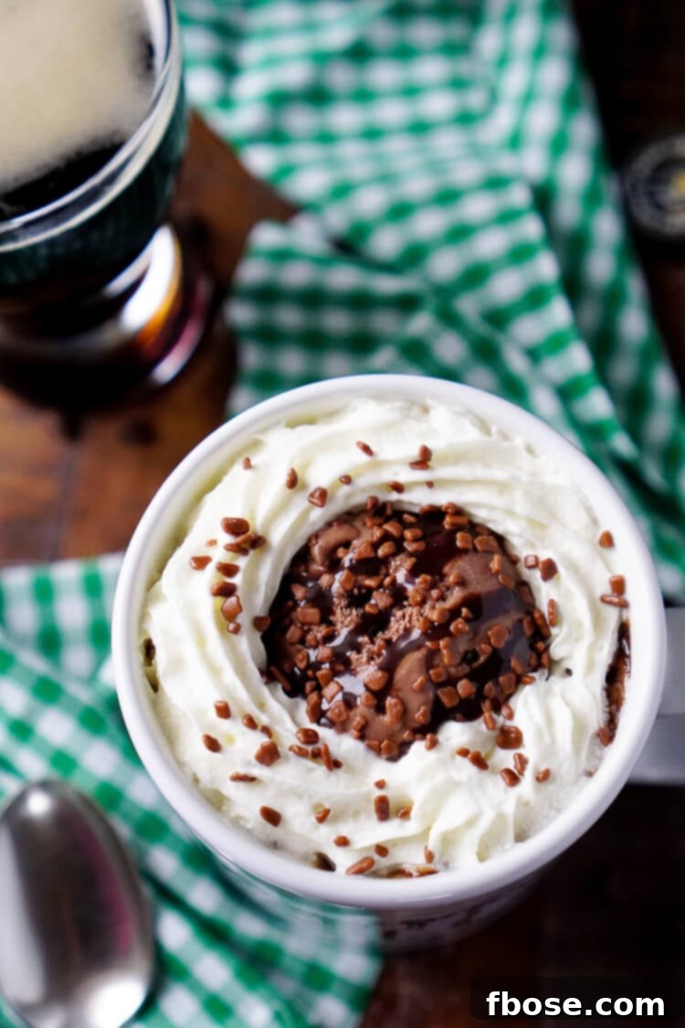 An overhead shot of Guinness Chocolate Mug Cake, garnished with fluffy whipped cream