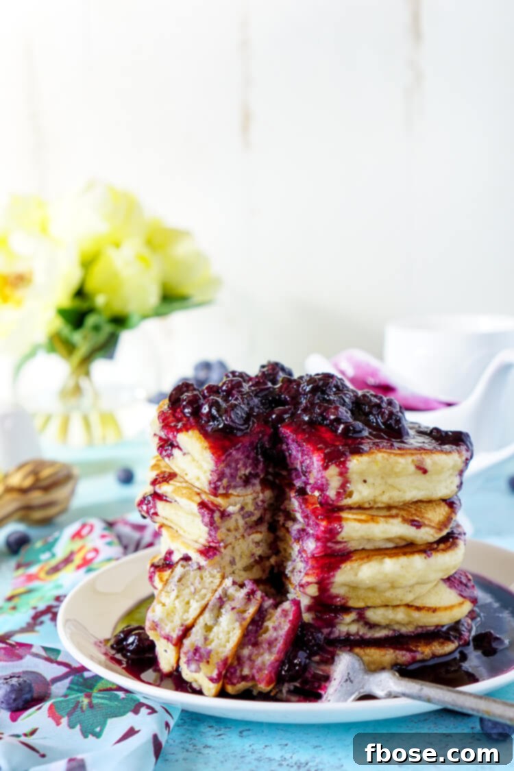 A delectable spread featuring Lemon Ricotta Pancakes, glistening with blueberry compote and fresh berries, perfect for breakfast.