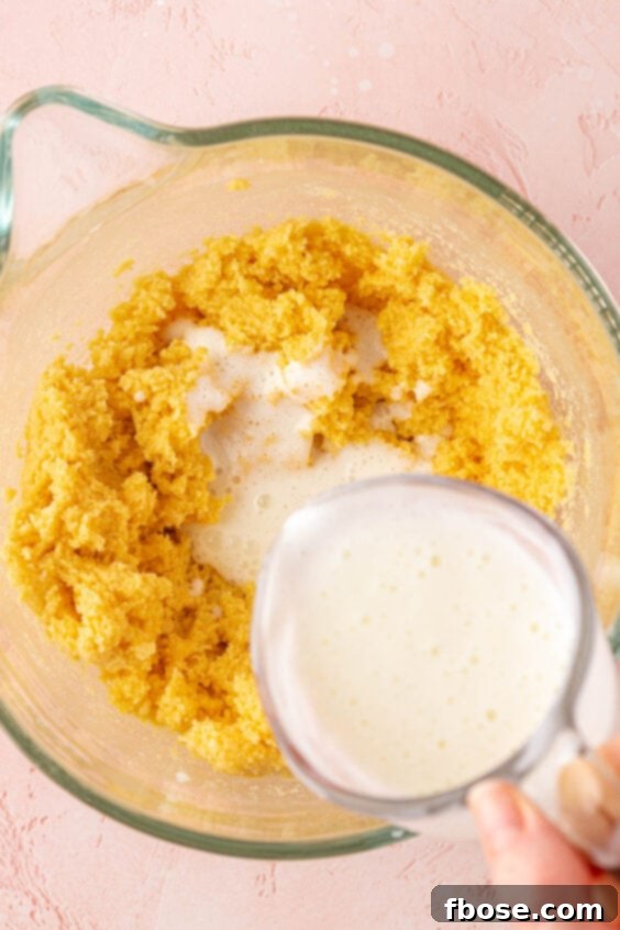 Buttermilk being added to make ingredients in a mixing bowl.