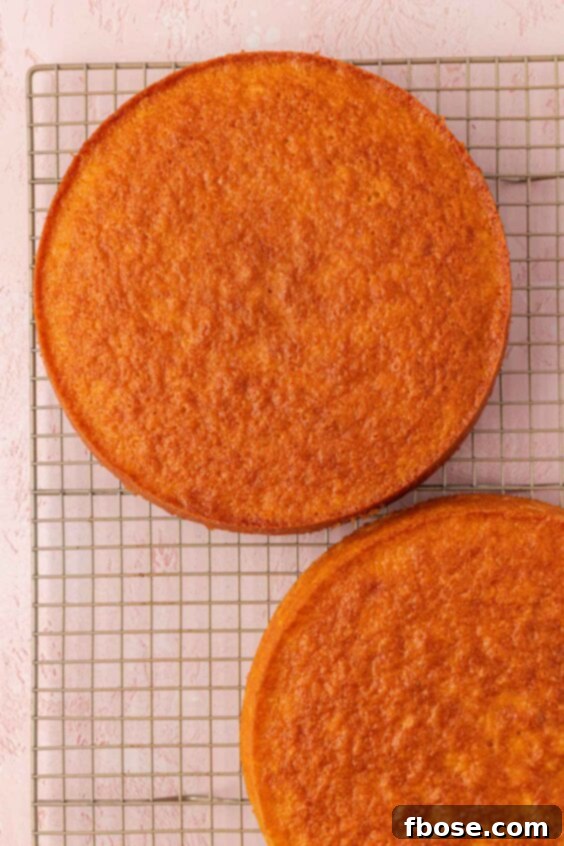 Baked cake rounds on a wire rack cooling.
