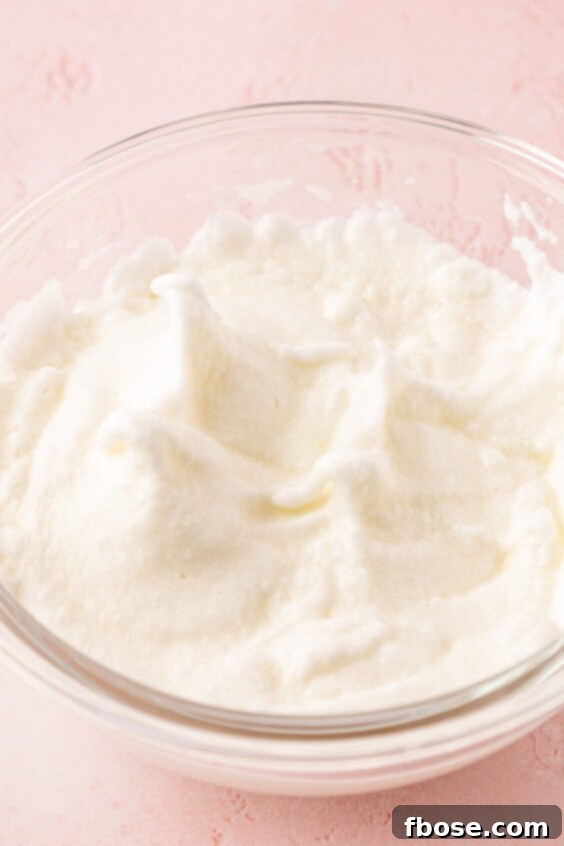 Egg whites in a bowl were whipped into stiff peaks.