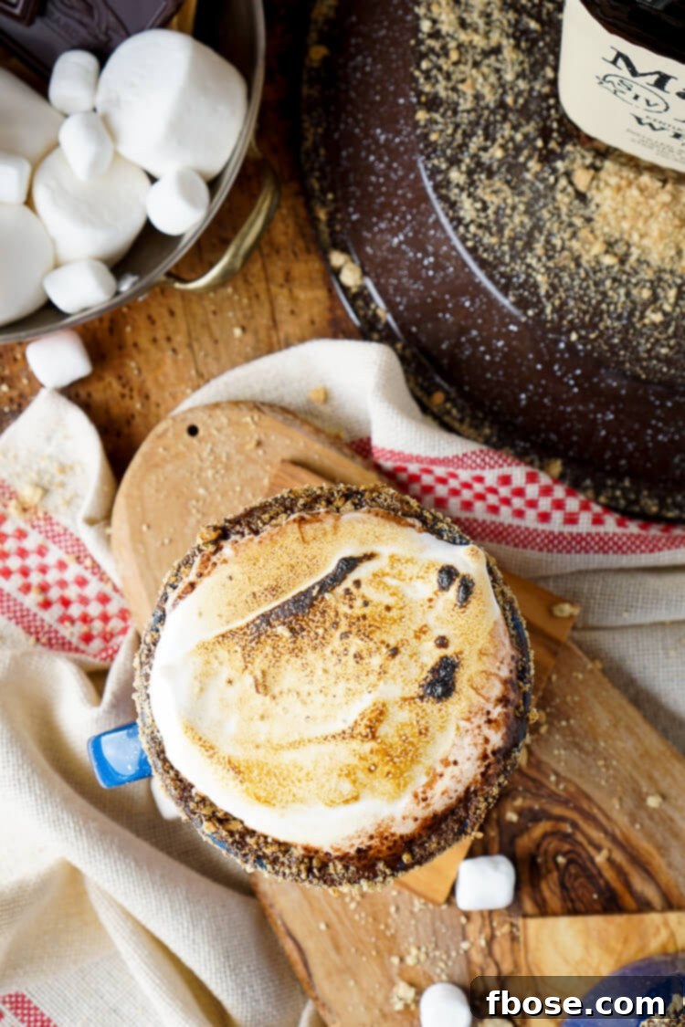 Enjoying a Campfire S'mores Hot Chocolate Cocktail, highlighting the perfect balance of richness and warmth.