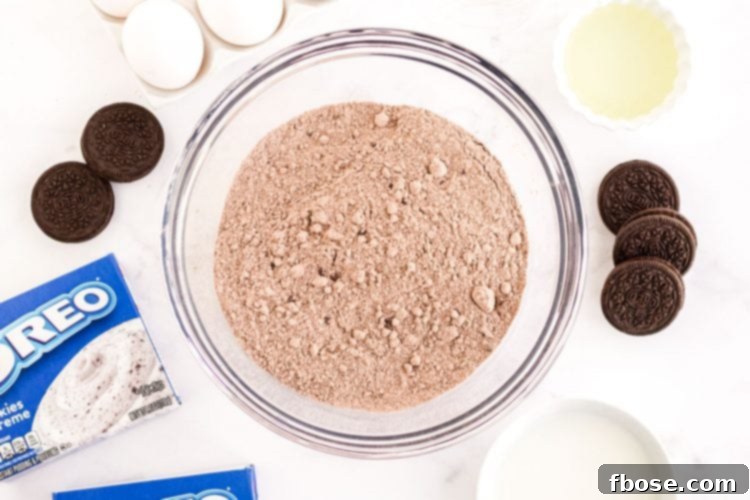 Overhead photo of ingredients used to make Oreo Poke Cake laid out on a marble counter.