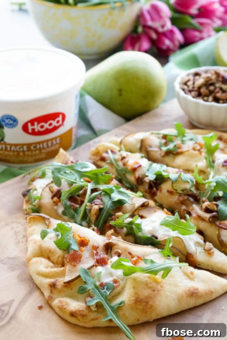 A beautifully garnished Honey Pear Bacon Flatbread, ideal for a light lunch, snack, or appetizer, offering a perfect balance of sweet and savory flavors.