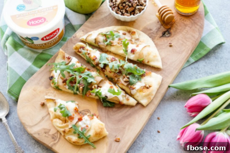 A beautifully presented Honey Pear Bacon Flatbread, artfully arranged on a wooden board, ready to be served as a sophisticated appetizer or light meal.