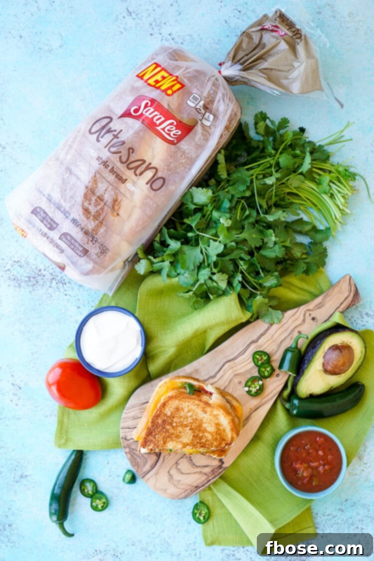 A close-up of a Taco Grilled Cheese Sandwich, with vibrant green avocado and red tomato peeking out.