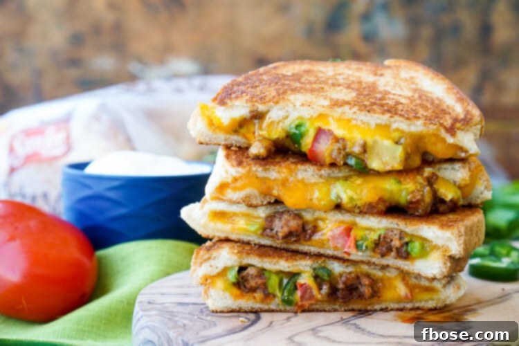 A close-up shot of a Taco Grilled Cheese Sandwich, showing the melted cheddar and vibrant fillings.