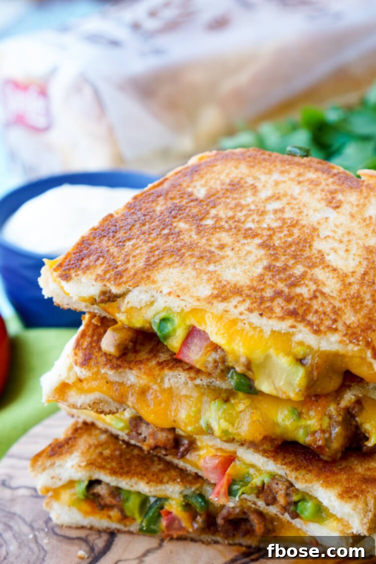 A stack of golden brown grilled cheese sandwiches, showing the delicious crust.
