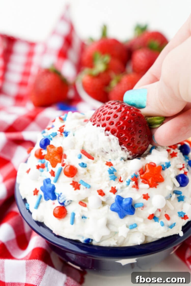 Red, White and Blue Cake Batter Dip 6 A serving bowl filled with Cake Batter Dip, topped generously with patriotic red, white, and blue sprinkles, ready for a Fourth of July celebration.