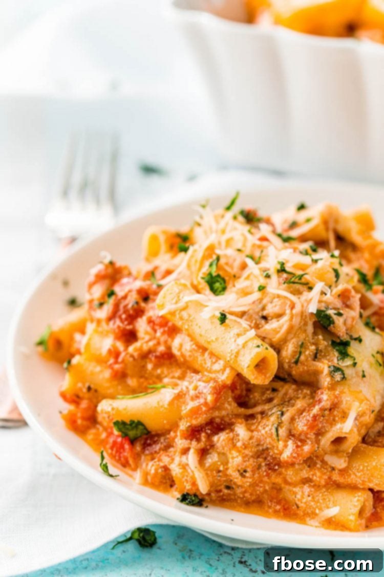 Deliciously Easy Baked Ziti 2 A generous serving of Baked Ziti on a pristine white plate, showcasing the melted cheese and rich sauce.
