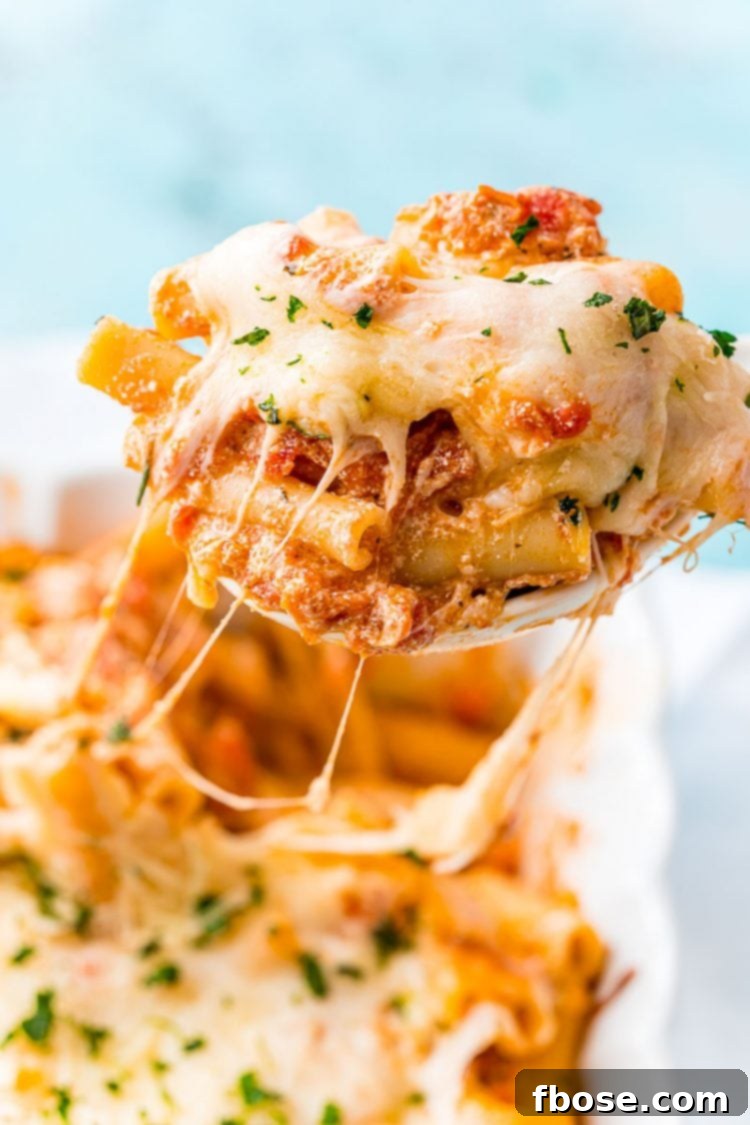 Deliciously Easy Baked Ziti 5 Baked Ziti being served from a casserole dish, highlighting its rich, cheesy texture.