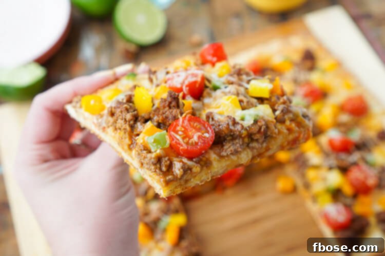 A perfectly baked Taco Pizza, golden brown crust, melted cheese, and seasoned beef, ready to be garnished and enjoyed.