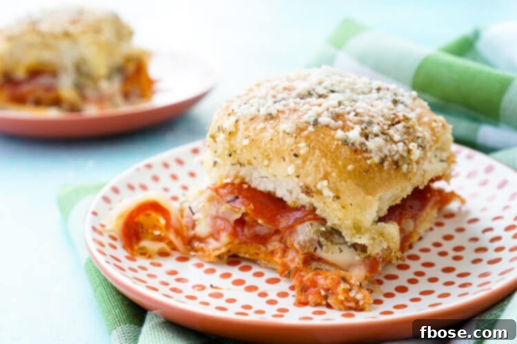 Close-up of golden brown Easy Pizza Sliders, showcasing the melted cheese and crispy toppings.
