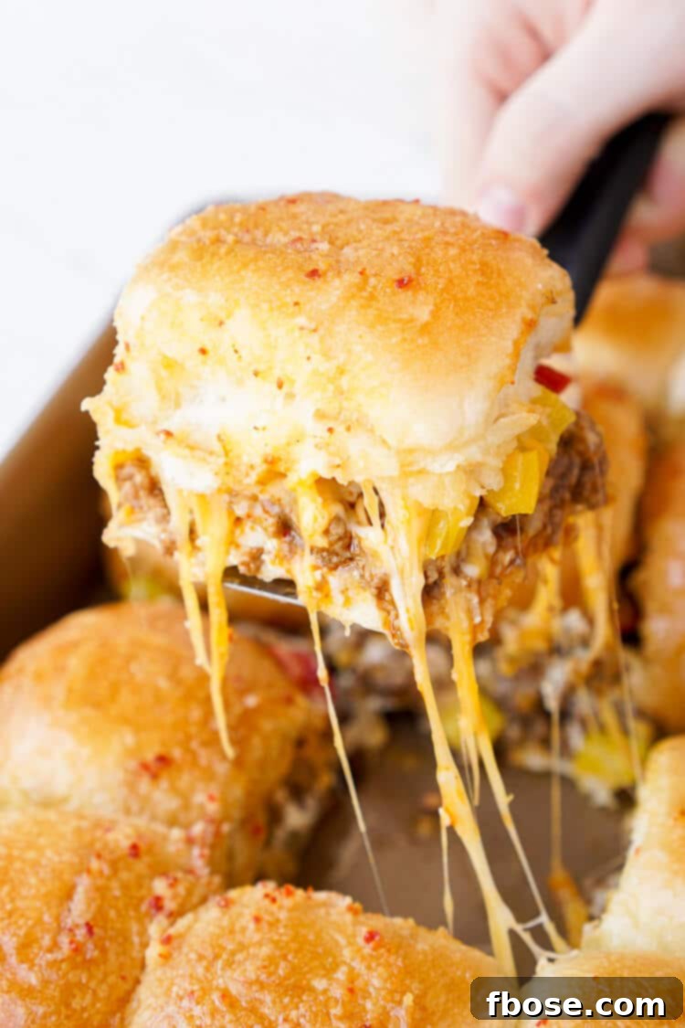 A close-up of delicious Taco Sliders, showing the golden-brown tops of the dinner rolls and the irresistible melted cheese beneath.
