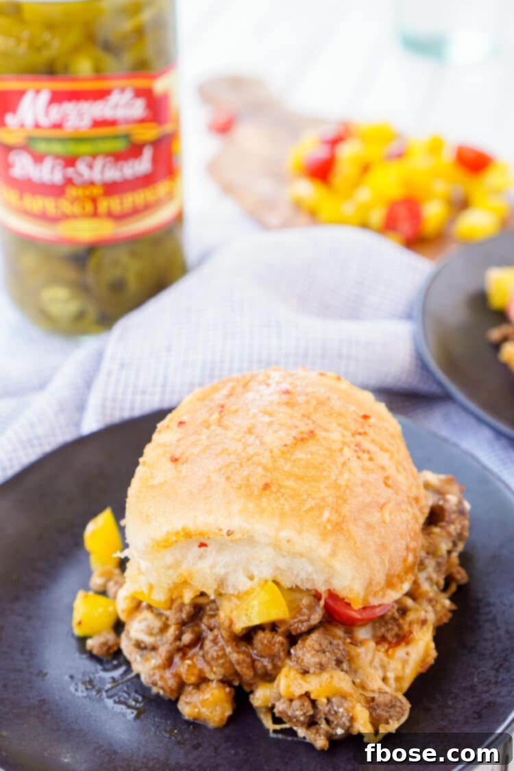 A cutting board filled with sliced Easy Taco Sliders, ready to be served, revealing the layers of filling.