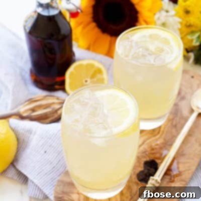 A glass of Maple Lemonade, garnished with lemon and a maple leaf.