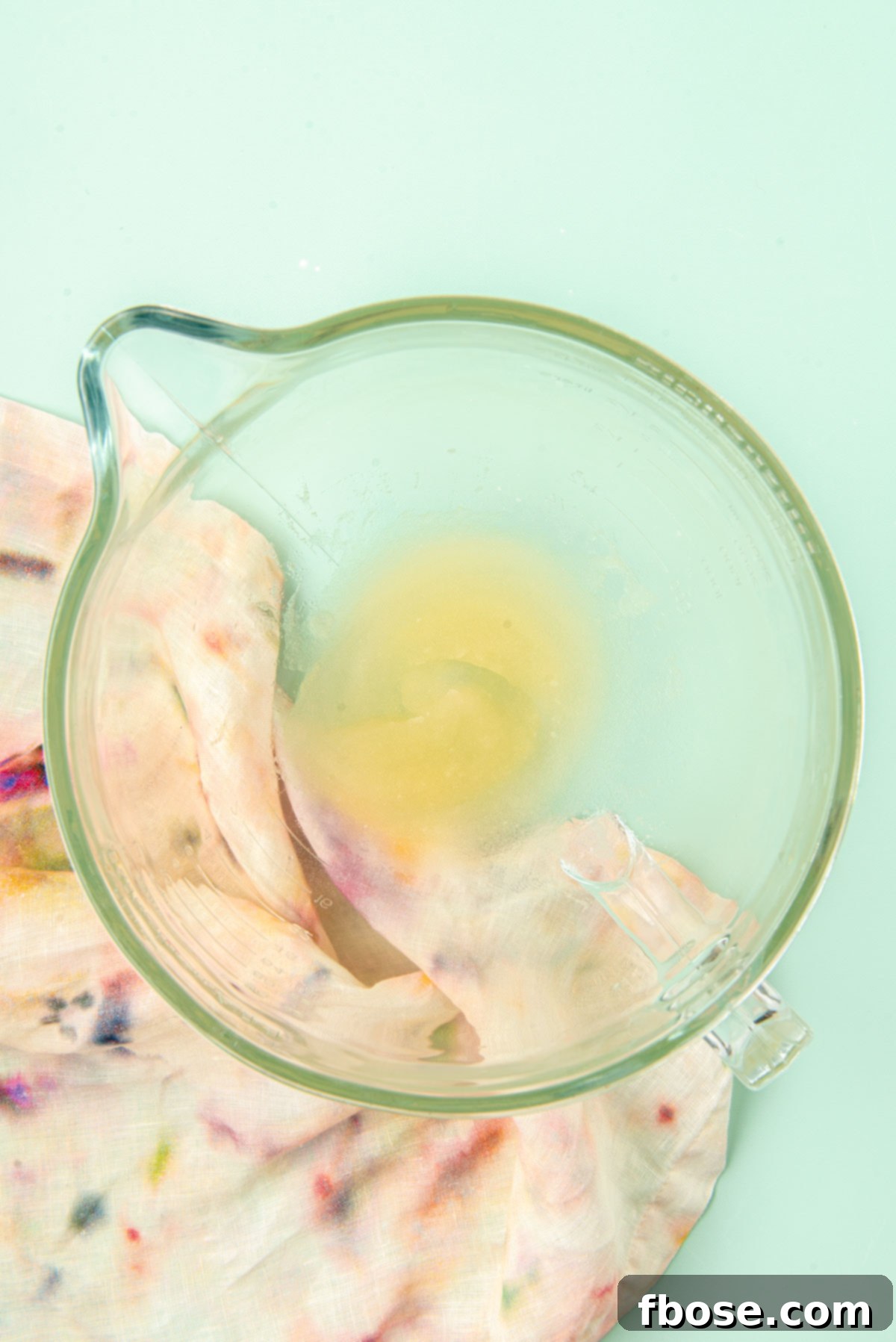 Gelatin and water resting in a clear glass mixing bowl, blooming and ready for the next step of the marshmallow recipe.