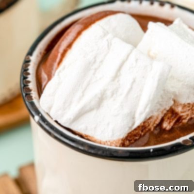 Homemade marshmallows in a white mug filled with hot chocolate, a cozy winter treat.