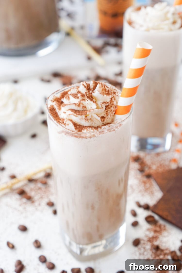 Overhead shot of a full glass of Mocha Coffee Punch garnished with whipped cream and cocoa, ready to drink
