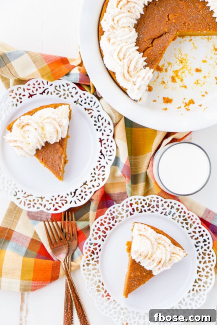 A beautifully sliced Impossible Pumpkin Pie, ready to be served, topped with a swirl of homemade whipped cream.