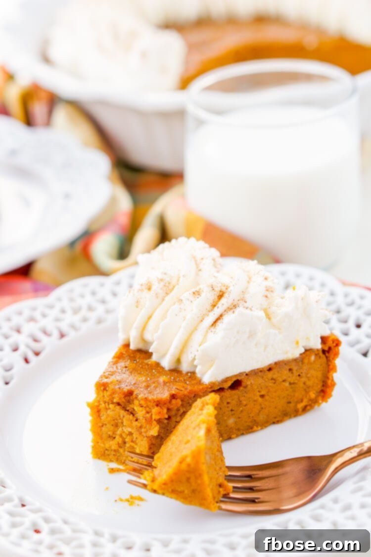 Seven beautifully presented Impossible Pumpkin Pie slices, each topped with a swirl of whipped cream, on a wooden serving board.